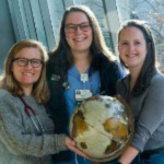 3 Global Health Students holding a globe