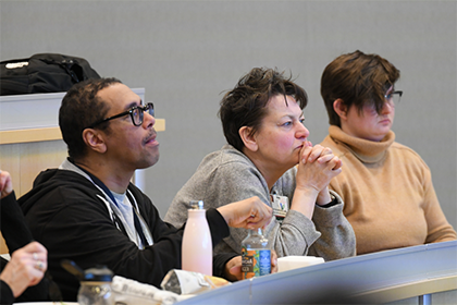 three people listening to a lecture