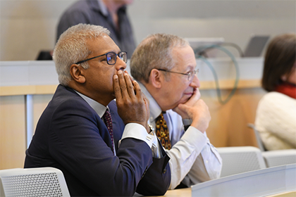 two men in the foreground listening to a lecture