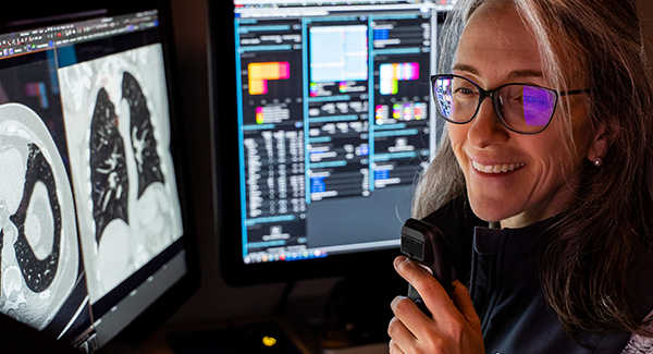 Dr. Zigmund sits amidst monitors showing low-dose CT lung cancer screening images.