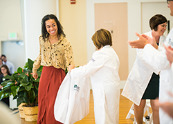 Events-1 medical student smiles as she dons her white coat