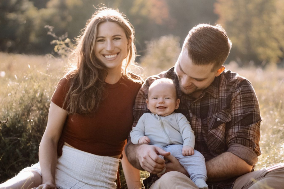 a woman and man and baby smiling