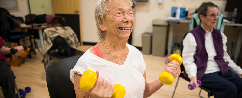 Person lifting weights in steps to wellness class.
